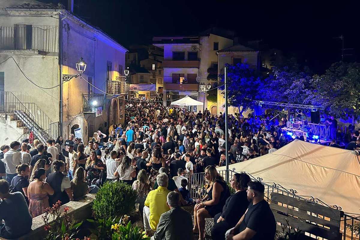 Concerto all'aperto in Piazza Rossetti a Vasto, folla di persone, palco illuminato, atmosfera estiva, dettagli architettonici visibili