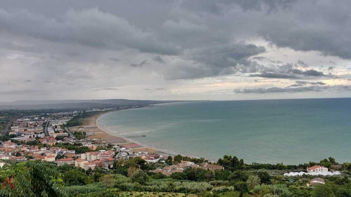 Scorcio panoramico della piazza centrale di Vasto durante una festa tradizionale serale, folla festante, luminarie e stand gastronomici, atmosfera vivace