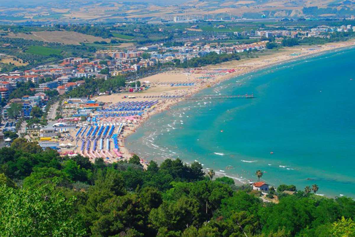 Parco giochi moderno di Vasto, bambini che si divertono, scivoli colorati, famiglie sorridenti, sfondo con scorcio di mare