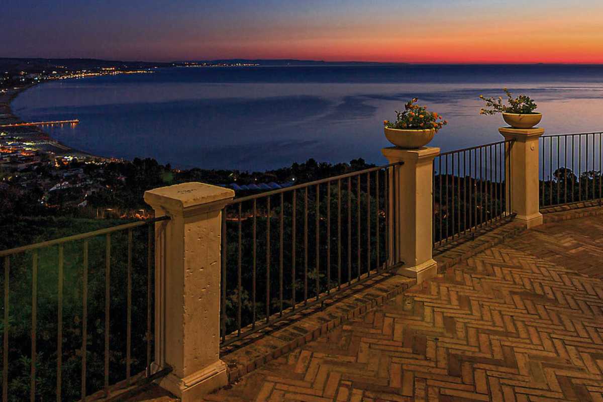 Coppia che passeggia al tramonto sulla Loggia Amblingh con vista mare e centro storico di Vasto